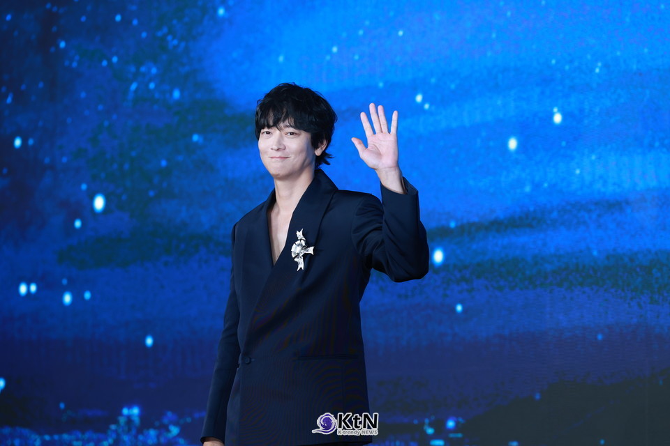 강동원은 네이비 테일러드 재킷+블랙 와이드 트라우저 조합에 실버 리본 브로치와 재킷 카라 뒤 대형(王) 리본을 더해, 미니멀 속 ‘한 방’을 보여줬다./사진=K trendy NEWS DB ⓒ케이 트렌디뉴스 무단전재 및 수집, 재배포금지