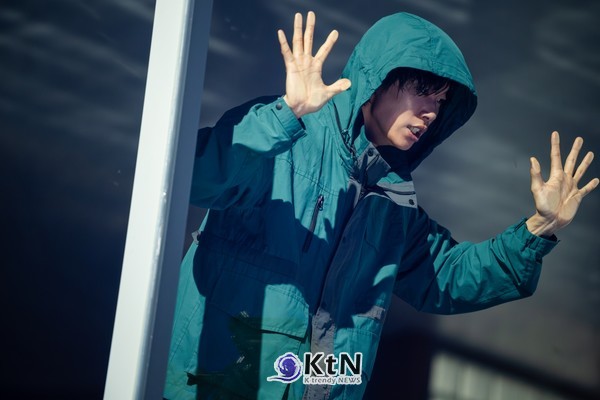 유리 너머에서 두 손을 든 문재. 신체는 눈앞에 있지만 유리의 경계는 문재를 사회 바깥에 세운다. 사진=넷플릭스