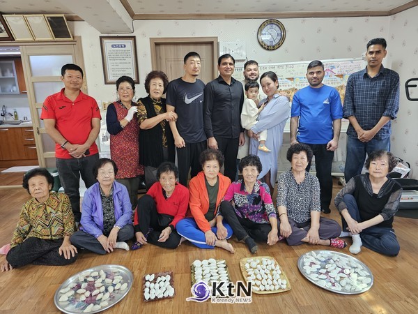 경로당 어르신과 외국인 노동자들이 함께 빚은 송편을 놓고 기념사진을 찍고 있다. (사진=조영식 기자)