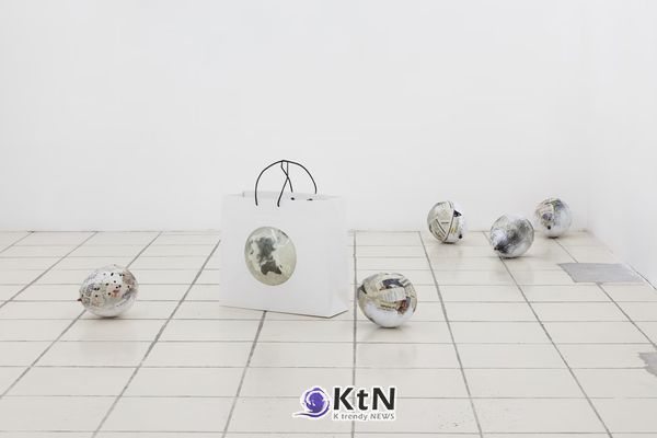멕시코시티 서드 본 공동전의 바닥 설치 작업. 격자무늬 타일 위에 인쇄 이미지가 겹친 구형 입체물들을 흩어 놓고, 중앙에는 둥근 이미지와 가느다란 금속 구조물이 결합된 흰색 입체물을 배치했다. 사진=@hiperfocal.arte, THIRD BORN·Market Gallery 제공