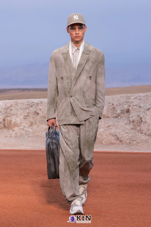 그레이 스웨이드 더블브레스티드 재킷과 넓은 팬츠를 조합한 Giorgio Armani × Kith FW26 'Dreams of the Dune'. 부드럽게 내려오는 어깨선과 여유로운 재킷의 품, 주름이 잡힌 팬츠에 야구 모자와 짙은 가죽 가방을 더했다. 사진=Kith and Giorgio Armani, K trendy NEWS DB ⓒ케이 트렌디뉴스 무단전재 및 수집, 재배포금지