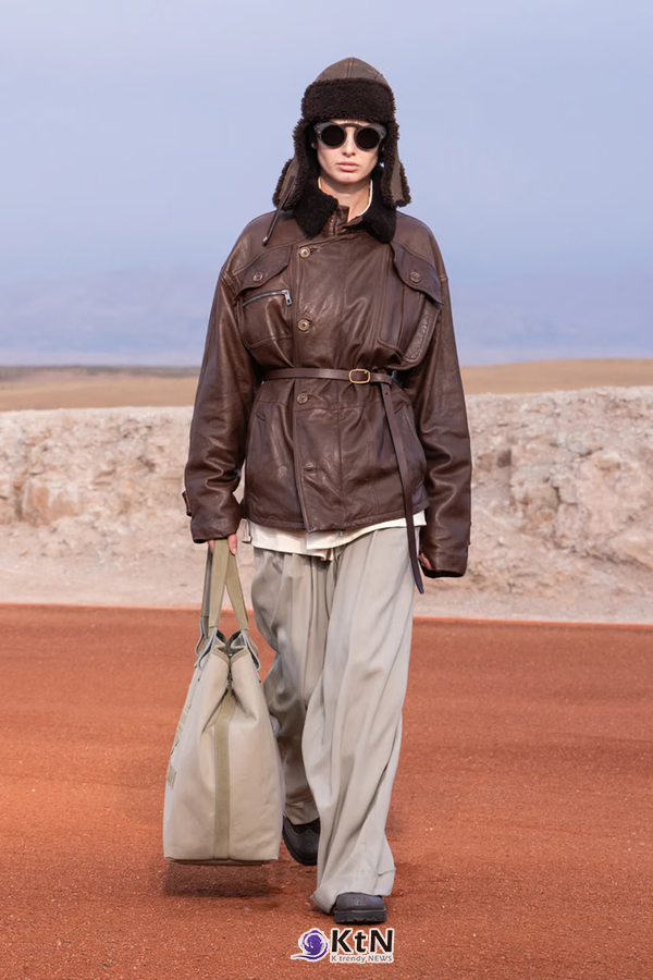 짙은 브라운 가죽 필드 재킷에 허리 벨트를 더하고 밝은 그레이 와이드 팬츠를 조합한 Giorgio Armani × Kith FW26 'Dreams of the Dune'. 시어링 트래퍼 모자와 선글라스, 밝은 색의 대형 캔버스 토트백을 함께 착용했다. 사진=Kith and Giorgio Armani, K trendy NEWS DB ⓒ케이 트렌디뉴스 무단전재 및 수집, 재배포금지