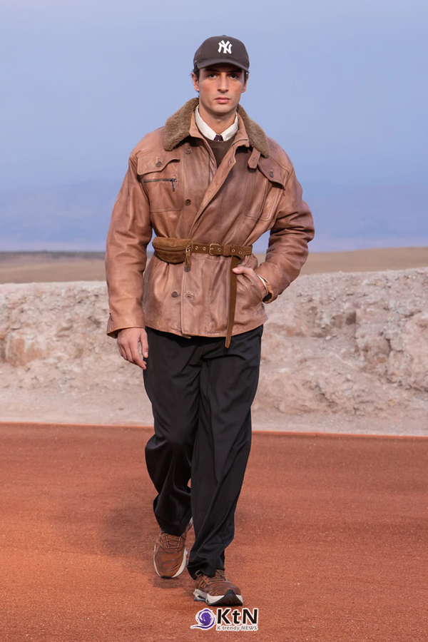 탄 컬러 가죽 필드 재킷에 허리 벨트를 더하고 검은 와이드 팬츠를 조합한 Giorgio Armani × Kith FW26 착장. 넓은 칼라와 포켓, 뉴욕 양키스 캡과 스웨이드 소재의 캐주얼 슈즈가 클래식한 가죽 재킷에 도시적인 요소를 더한다. 사진=Kith and Giorgio Armani, K trendy NEWS DB ⓒ케이 트렌디뉴스 무단전재 및 수집, 재배포금지