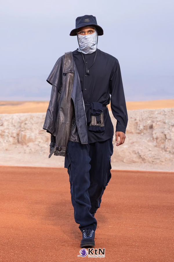 네이비 셔츠 재킷에 허리 파우치와 넓은 카고 팬츠를 조합한 Giorgio Armani × Kith FW26 'Dreams of the Dune'. 검은 가죽 재킷을 어깨에 걸치고 버킷햇과 얼굴을 감싸는 스카프를 더해 기능적인 레이어링을 구성했다. 사진=Kith and Giorgio Armani, K trendy NEWS DB ⓒ케이 트렌디뉴스 무단전재 및 수집, 재배포금지