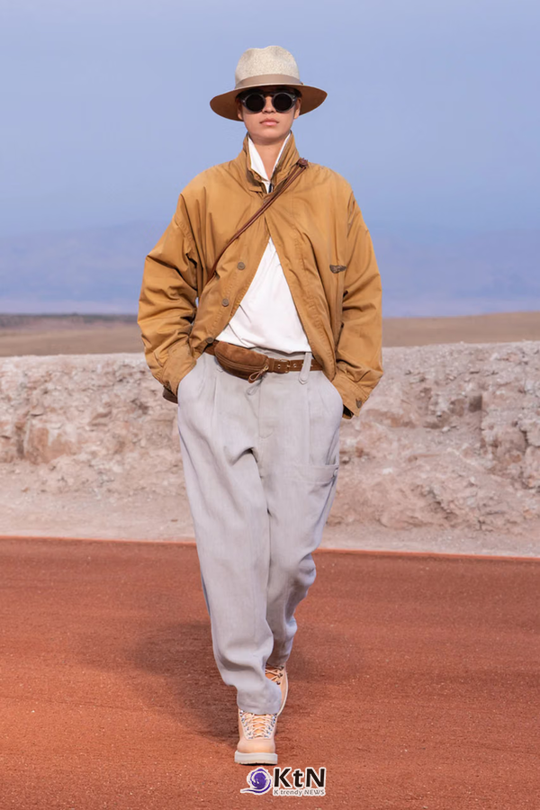 탄 컬러 코튼 블루종에 흰 티셔츠와 밝은 그레이 주름 팬츠를 조합한 Giorgio Armani × Kith FW26 착장. 가슴 부근의 사선 구성과 브라운 벨트·허리 파우치, 밀짚 페도라와 밝은 신발이 따뜻한 색의 상의와 차분한 하의를 연결한다. 사진=Kith and Giorgio Armani, K trendy NEWS DB ⓒ케이 트렌디뉴스 무단전재 및 수집, 재배포금지