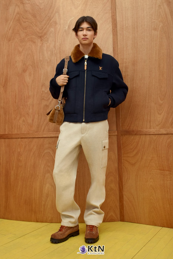 브라운 털 칼라가 달린 짙은 네이비 재킷에 크림색 와이드 팬츠와 갈색 신발을 매치했다. 짧은 재킷과 밝은 팬츠의 대비, 작은 갈색 가방이 특징이다. 사진=Louis Vuitton